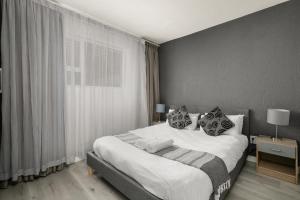 a bedroom with a large bed with white sheets and pillows at Marley on Katherine Apartments in Johannesburg