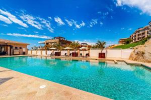 una piscina con acqua blu in un resort di Tramonti Condo Tari #107 a Cabo San Lucas