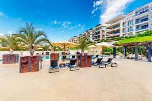 a group of chairs and umbrellas on a beach at Tramonti Condo Tari #107 in Cabo San Lucas