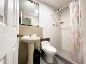 a white bathroom with a toilet and a sink at Casa Justina in Cusco
