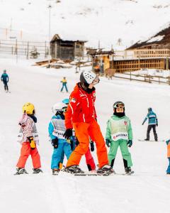 un gruppo di bambini sugli sci nella neve di Le Loup, grand chalet coup de cœur a Moleson