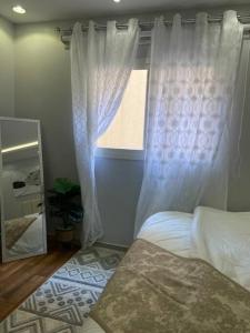 1 dormitorio con ventana, cama y espejo en استديو بتصميم أنيق ودخول ذاتي en Riad