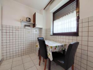 a kitchen with a table and two chairs and a window at Apartments Marija in Selce
