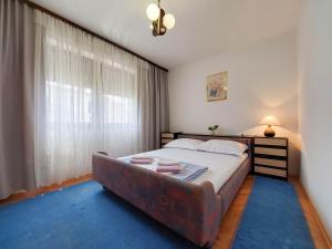 a bedroom with a bed with a couch in front of a window at Apartments Marija in Selce +50 photos