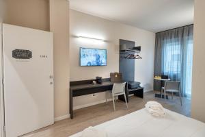 um quarto de hotel com uma secretária e uma cama em Astoria Comfort Rooms em Bolonha