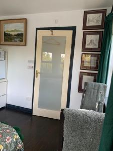 a room with a door and a chair and pictures at Isserkelly House in Clonbur