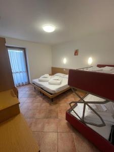 a room with two beds and a window at Casa Santa Maria in Folgaria