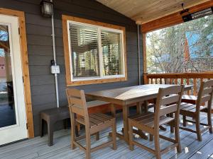 a wooden table and chairs on the porch of a cabin at Compass Cabin by NW Comfy Cabins in Leavenworth