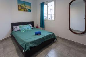 um quarto com uma cama com lençóis verdes e um espelho em L escale de bois dO em Saint-Pierre