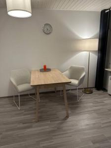 a room with a table and two chairs and a clock at Ferienwohnung zur Sternblume in Bruchweiler-Bärenbach +5 photos