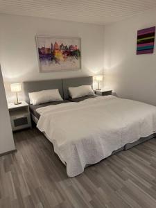ein Schlafzimmer mit einem großen weißen Bett mit zwei Nachttischen in der Unterkunft Ferienwohnung zur Sternblume in Bruchweiler-Bärenbach