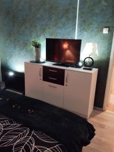 a living room with a tv on a white cabinet at APARTMAN PARK in Šabac