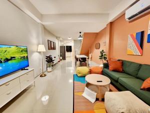 4 bedrooms, Private & Cozy house @ Walking Street في شيانج راي: غرفة معيشة مع أريكة خضراء وتلفزيون بشاشة مسطحة