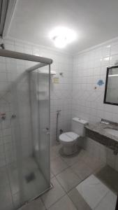 a bathroom with a toilet and a glass shower at Hotel Tenda in Marília