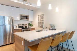 cocina con nevera de acero inoxidable y sillas en Gymking Bed4k Smart Tvcable360 Rooftop Views, en Tacoma