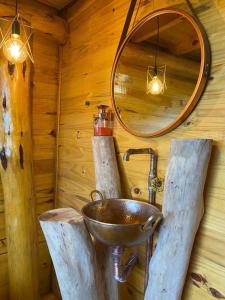 uma casa de banho com um lavatório num chalé de madeira em Chalés Recando do Vale - TIRIVA em Bom Jardim da Serra