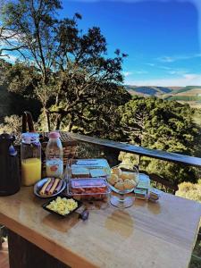 a picnic table with food and drinks on a table at Chalés Recando do Vale - TIRIVA in Bom Jardim da Serra
