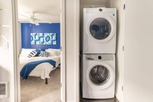 een kamer met een wasmachine en een bed bij Paid Garage Parking- King Bed-balcony Wd 55" Tv in Tacoma