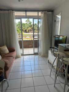 a living room with a couch and a tv at Gran Lencois Flat Residence in Barreirinhas