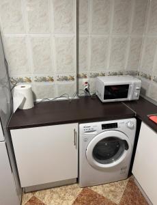 a kitchen with a washing machine and a microwave at El Gengo Suite in Madrid