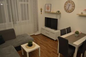 Apartmán u Fontány في بودبرادي: غرفة معيشة مع أريكة وطاولة مع تلفزيون