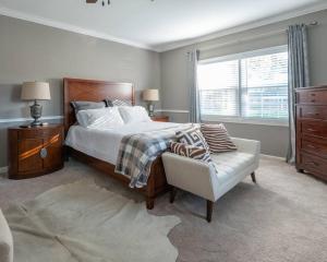 a bedroom with a bed and a chair and a window at Fernwood Manor in High Point