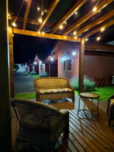 a deck with chairs and a table and lights at Pousada Morada dos Sonhos in Urubici