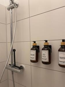 three bottles of soap on a wall in a bathroom at City Apartment Messe Zentral PS4 Workspace in Frankfurt