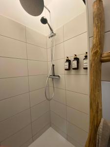 a shower with a shower head in a bathroom at City Apartment Messe Zentral PS4 Workspace in Frankfurt