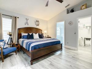 a bedroom with a bed and a blue chair at Casita mi Encanto a Cozy & Spacious House, 4-bedroom 3-Bath & pool in Kissimmee