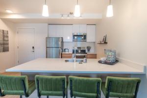 uma cozinha com uma grande ilha com cadeiras verdes em Top Floorbalcony55" 4k Smart Tv360 Rooftop View em Tacoma