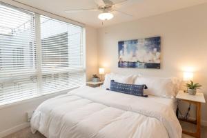 um quarto com uma grande cama branca e uma ventoinha de tecto em Top Floorbalcony55" 4k Smart Tv360 Rooftop View em Tacoma