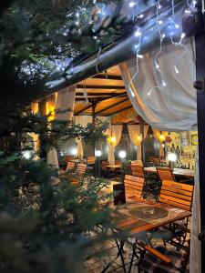 a restaurant with wooden tables and chairs and lights at Pensiune Restaurant Arconi in Năvodari