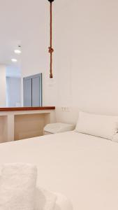 a bedroom with a white bed and a mirror at Bolivia Beach Suite A in Málaga