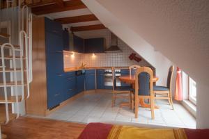 a kitchen with blue cabinets and a table and chairs at Ferienwohnung-Bordesholm / Inh. Fam. Gabriel in Bordesholm
