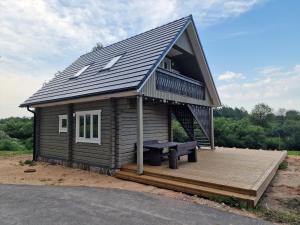 a small cabin with a deck and a roof at Jõesuu saunamaja in Valga