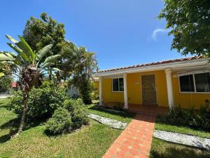 a yellow house with a palm tree in the yard at Luxury Stay- Brickell & Little Havana/ItalianPlaza in Miami