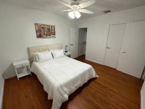 a bedroom with a white bed and a ceiling fan at Luxury Stay- Brickell & Little Havana/ItalianPlaza in Miami