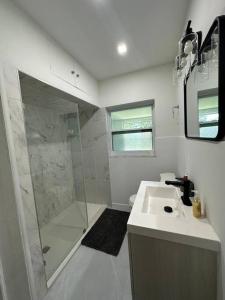 a white bathroom with a shower and a sink at Luxury Stay- Brickell & Little Havana/ItalianPlaza in Miami