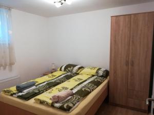 een slaapkamer met een bed met een geel dekbed bij Apartman Žujan in Divčibare