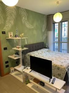 a bedroom with a bed and a flat screen tv at “The green house” Fiera Milano in Pero