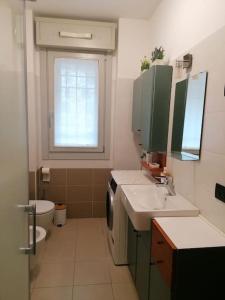 a bathroom with a sink and a toilet and a window at “The green house” Fiera Milano in Pero