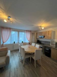 eine Küche und ein Esszimmer mit einem Tisch und Stühlen in der Unterkunft Gîte la perle rose 50 m² in Orchies