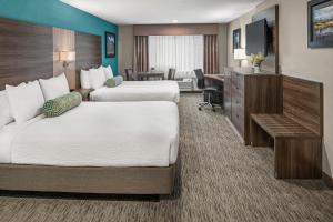 una camera d'albergo con 2 letti e una scrivania di Yosemite Southgate Hotel & Suites a Oakhurst
