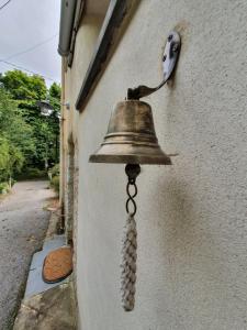 a bell hanging on the side of a building at Primrose Cottage in Helston