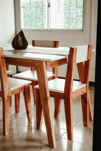 un tavolo in legno con due sedie, un tavolo e una finestra di Casa Tipo Loft- Tigre Centro a Tigre