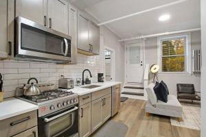 a kitchen with a stove and a sink and a microwave at Cozy Chic 1BR Chicago Apartment - Hartrey G in Evanston