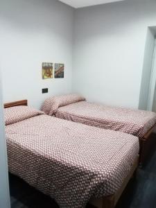 2 nebeneinander sitzende Betten in einem Schlafzimmer in der Unterkunft Centro Castillo 9 in Cáceres
