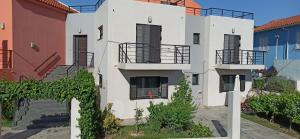 un edificio blanco con escaleras y balcones en Casa Luminosa Guesthouse, en Lixouri