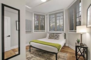a bedroom with a bed in a room with windows at Cozy Chic 1BR Chicago Apartment - Hartrey G in Evanston